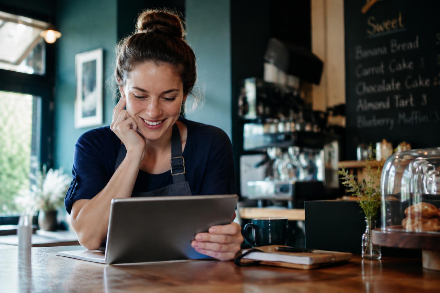 Café owner checking bookings on a tablet
